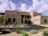 A large house with a driveway and cactus.