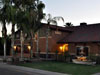 A large brown building with palm trees in the background.