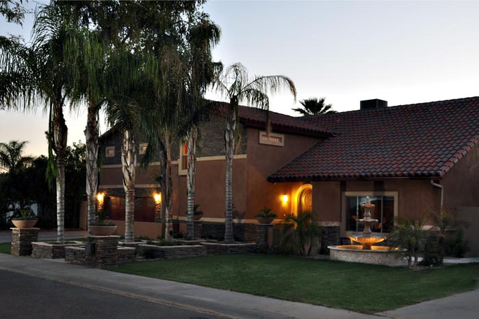MAX CLUB NO. 41 A large brown house with palm trees in the background.